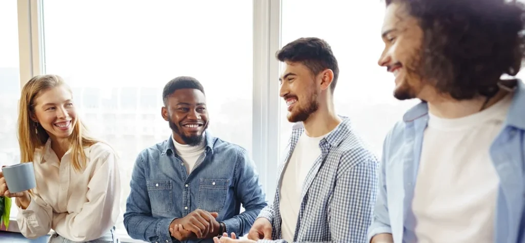 Collègues souriants partageant un moment convivial au travail grâce aux avantages sociaux du CSE